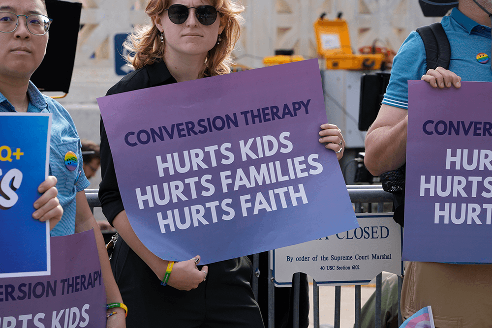 person holding sign at rally - Conversion Therapy Hurts Kids, Hurts Families, Hurts Faith