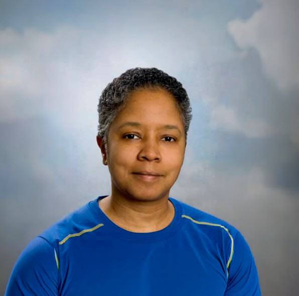 Eva Boyce, a light skinned Black woman with short salt and pepper curls and a kind smile